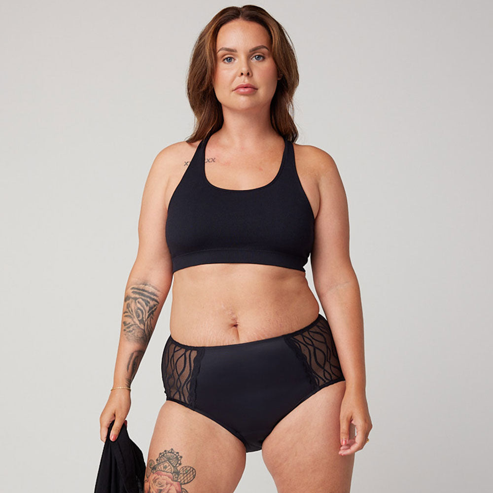 Femme portant Sous-vêtements absorbants lavables TENA Silhouette | Classique, illustrant leur design discret et confortable pour l'incontinence légère. Une main tient le tissu doux et élastique.