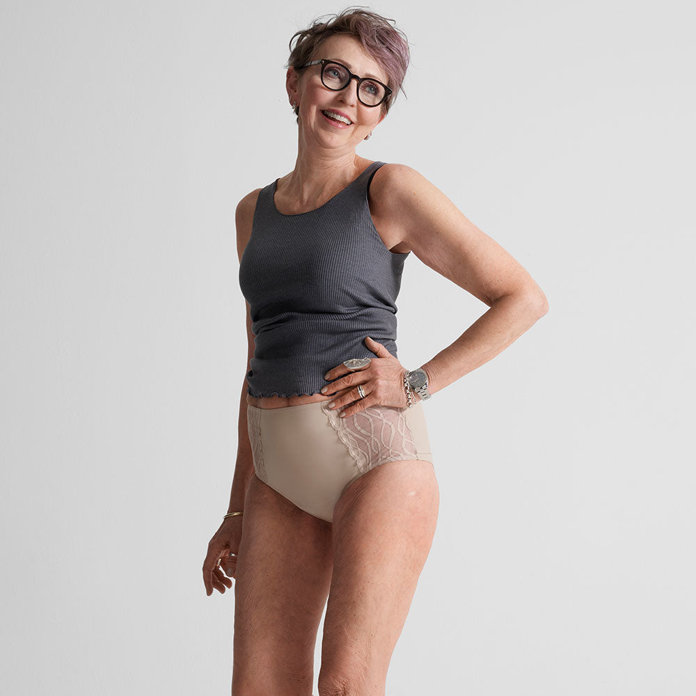 Femme portant des sous-vêtements absorbants lavables TENA Silhouette Classique, souriante, en mettant en valeur leur confort et protection discrète pour l'incontinence légère.