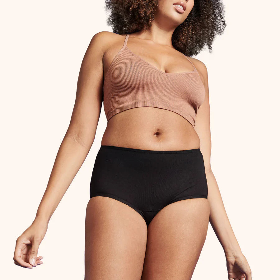 Femme portant la TENA Culotte Absorbante Lavable en Coton Doux, Lot de 3, offrant confort et protection contre les fuites urinaires, coupe haute et extensible.