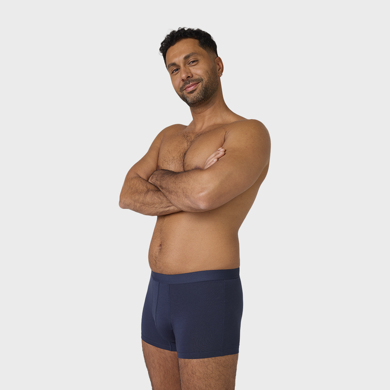 Homme en Nouveau Boxer absorbant lavable, bras croisés, montrant le design discret et confortable, idéal pour l’incontinence légère, fabriqué en coton biologique.