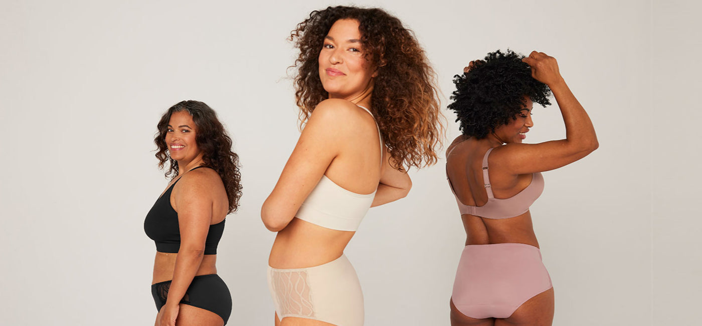 Trois femmes portent des sous-vêtements lavables noirs, roses et beiges, l'accent est mis sur la culotte d'incontinence lavable Silhouette Classic taille haute avec de la dentelle dans un studio lumineux.