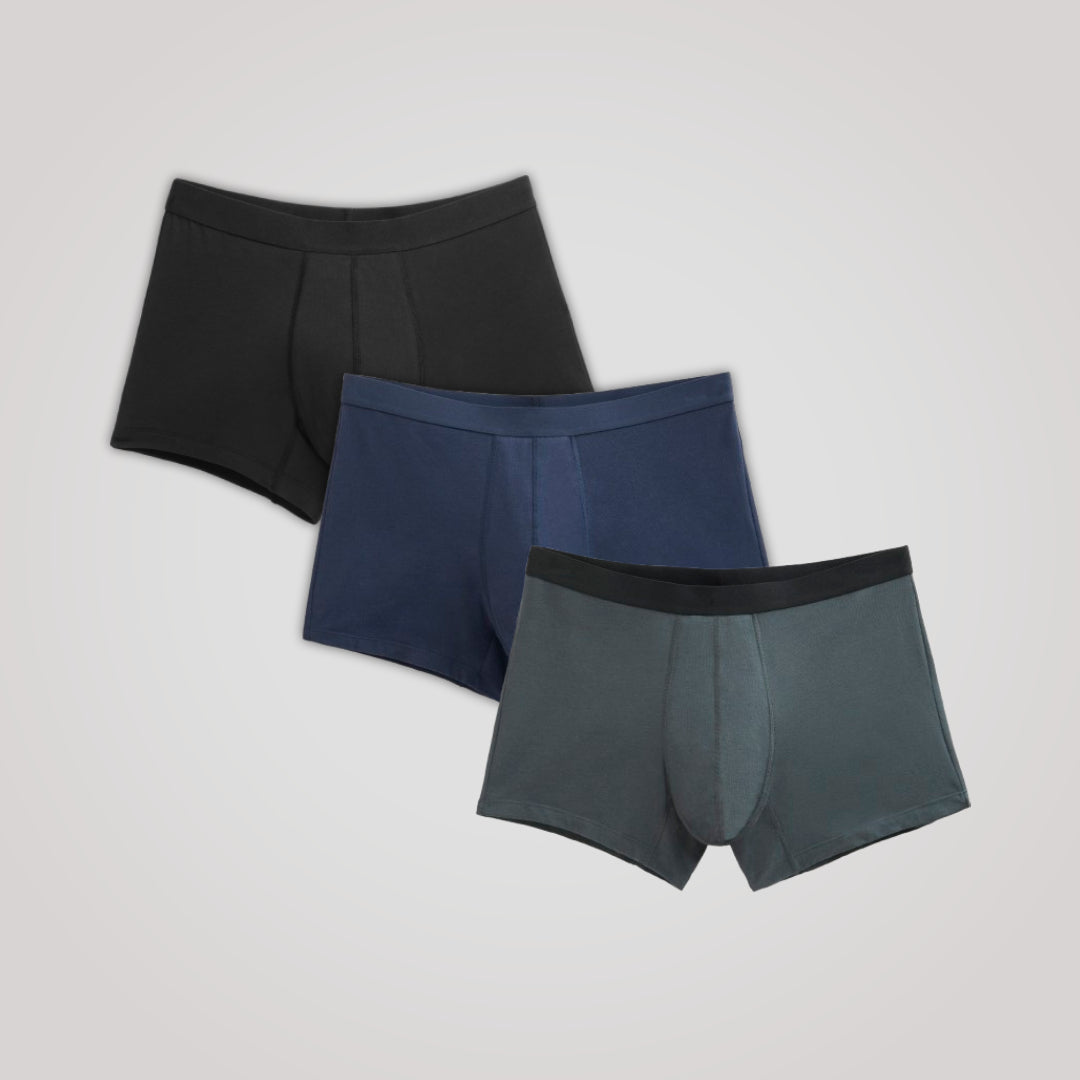 TENA Men 3 Pack Boxer Absorbant, trois boxers-trunks pour homme, offrant protection contre l'incontinence, fabriqués en coton biologique doux, disposés sur un fond clair.