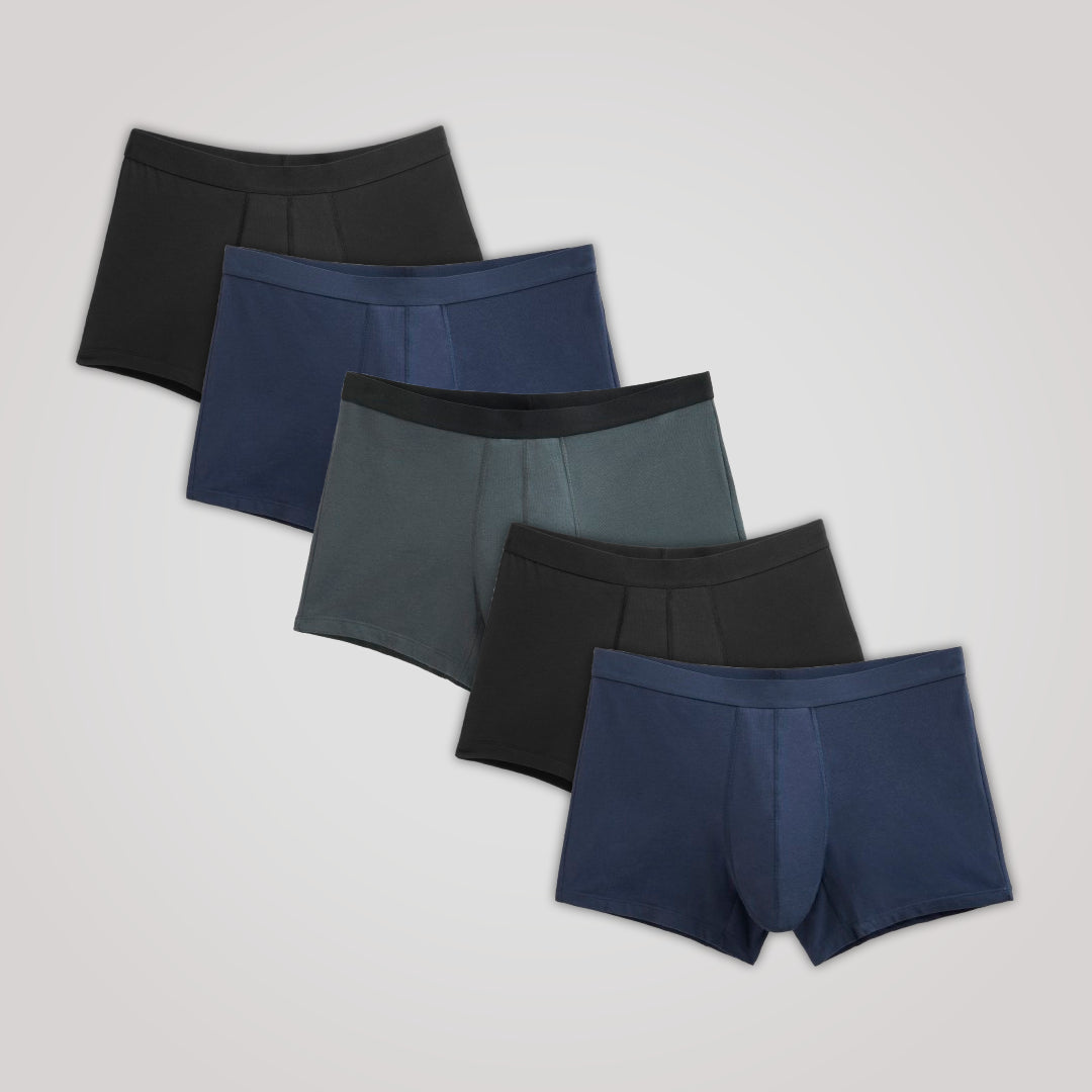 Lot de 5 Boxers Absorbants TENA Men, disposés en éventail, offrant confort et protection discrète contre l'incontinence avec doublure en coton biologique.